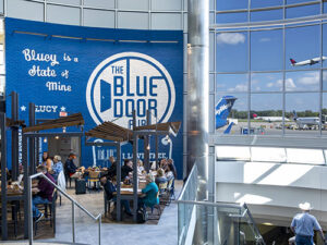 A group dining at Blue Door Pub with a plane taking off in the background