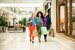 3 women walking through Mall of America with shopping bags