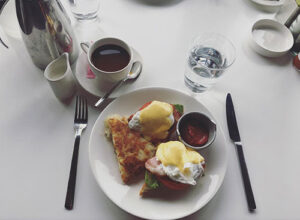 A plate with eggs benedict and hash browns at FireLake Grill House & Cocktail Bar