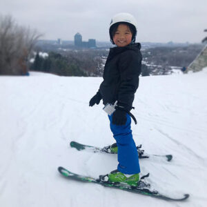 A girl stands on skis on a snowy slope at Hyland Hills Ski Area