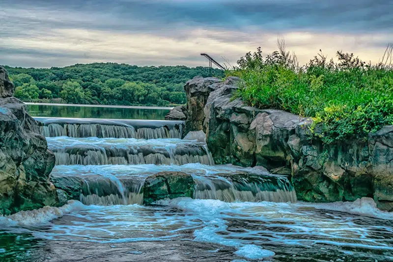 The waterfall at Normandale Lake with a ski jump in the background on a spring day