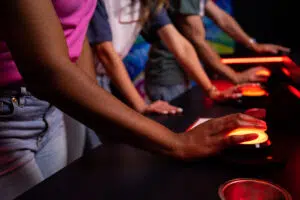 Close-up of hands hovering over game buzzers