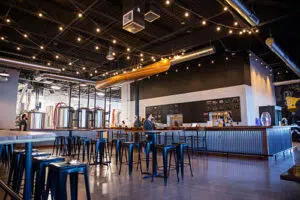 Empty tables and chairs in front of the bar at Nine Mile Brewing