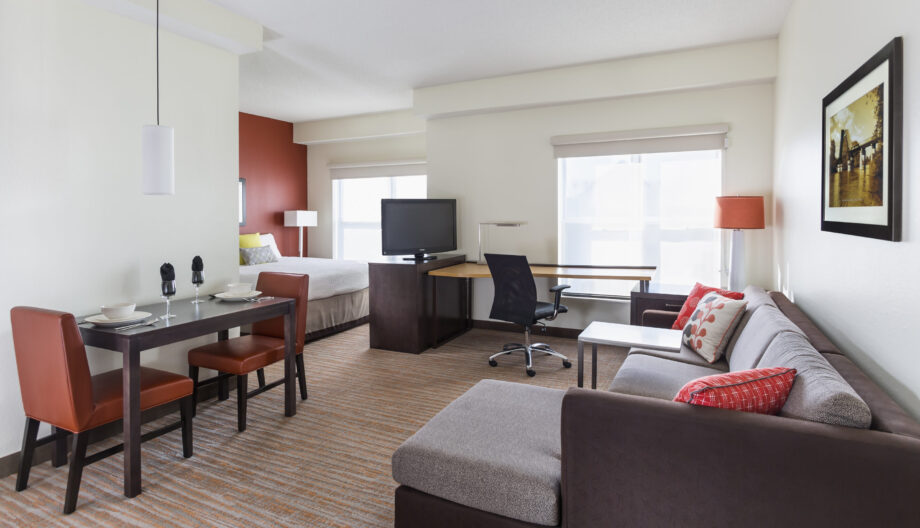 Hotel studio room with bright orange accent colors