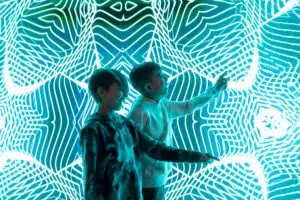 Two kids pointing at a light show at Museum of Illusions