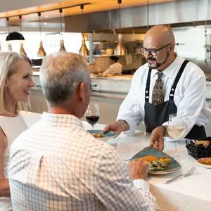 image of couple dining with chef