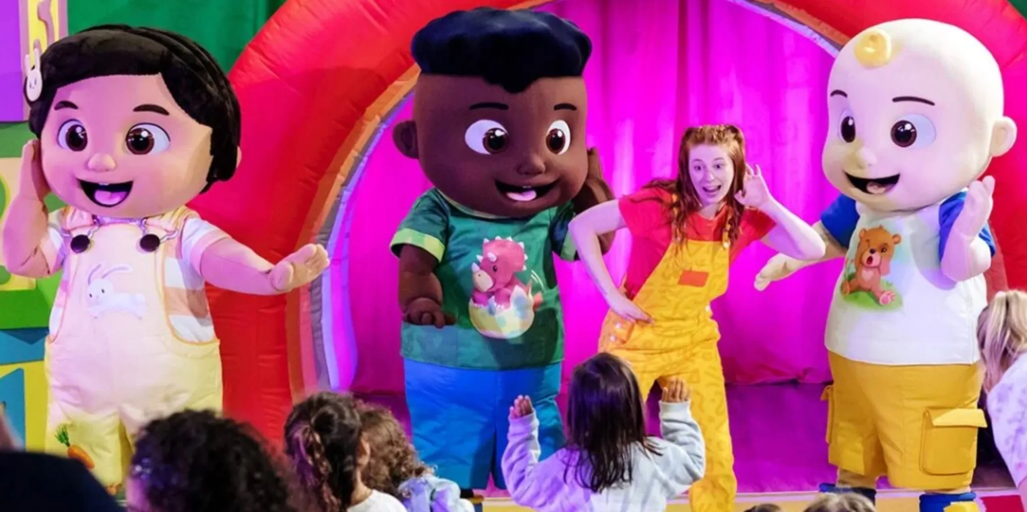 Life-size characters from Cocomelon, plus a human, dance on stage