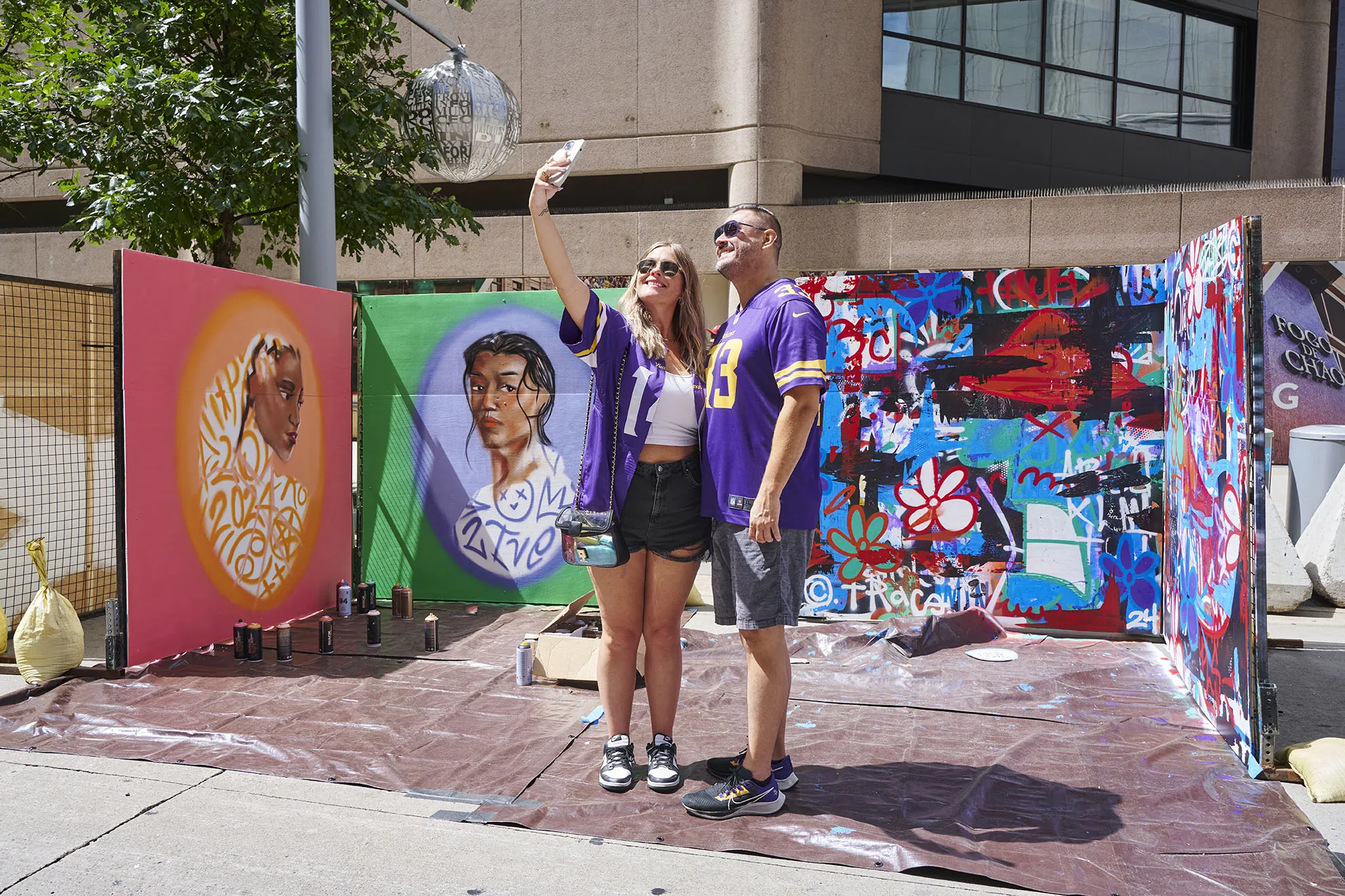 A couple takes a selfie in front of graffiti art