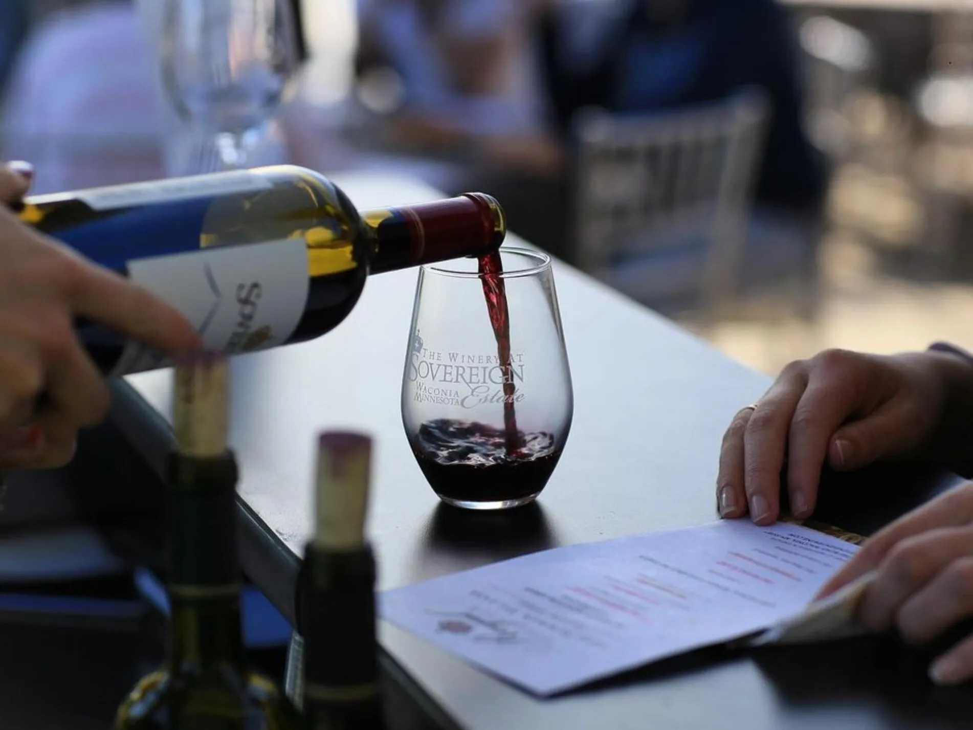 Wine is poured into a wine glass engraved with The Winery at Sovereign Estate